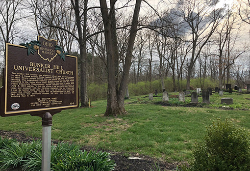 Ohio historical marker sign providing details on Bunker Hill Cemetery with grave markers in the background