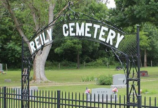 Entry gate reading Reily Cemetery in front of a cemetery